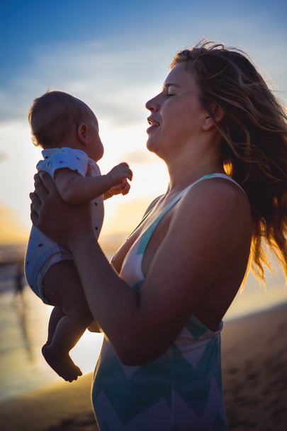  Moeder met haar baby op het strand   - Foto, afbeelding