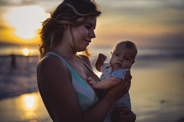  Mother with her baby on the beach   - Valokuva, kuva