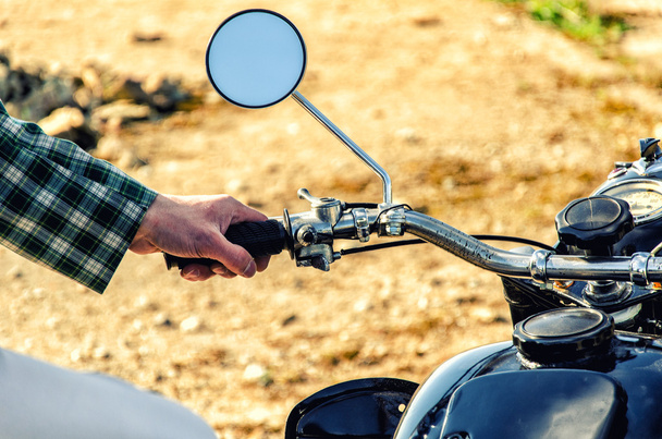 La mano dell'uomo poggia sulla moto del volante
 - Foto, immagini