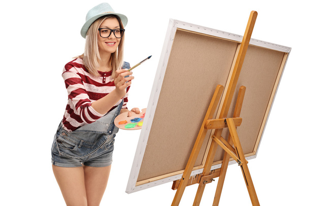 Young woman painting on a canvas - 写真・画像