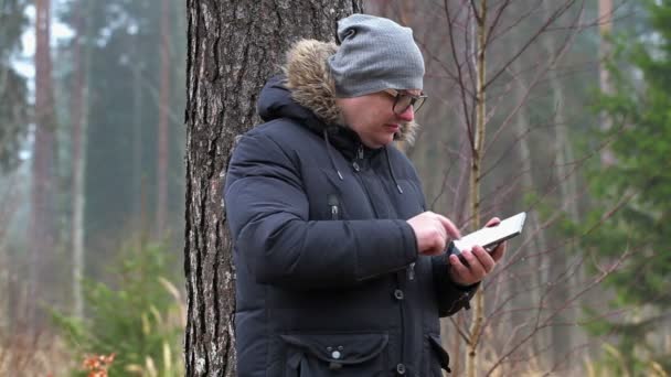 Homme avec tablette PC à la recherche de connexion dans la forêt
  - Séquence, vidéo