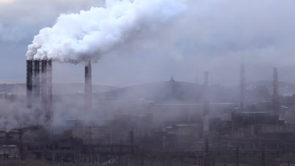 Luftverschmutzung durch Industrieanlagen. große Anlage auf dem Hintergrund der Stadt. Pfeifen werfen Rauch in den Himmel - Filmmaterial, Video