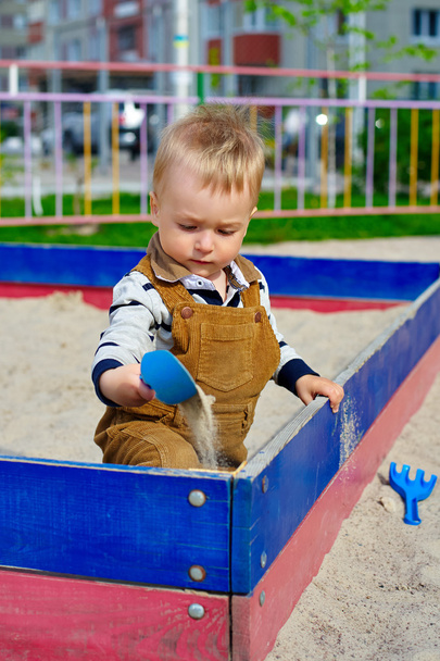 Mały chłopiec gra w piaskownicy na placu zabaw - Zdjęcie, obraz