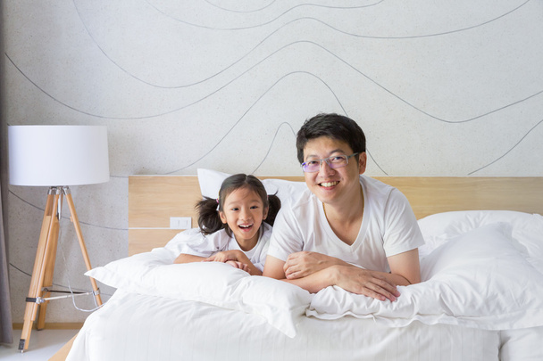 glücklich asiatische Familie Vater und Tochter lächelnd auf Bett - Foto, Bild