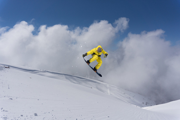 Сноубордист прыгает по горам. Экстремальный фрирайд на сноуборде. - Фото, изображение
