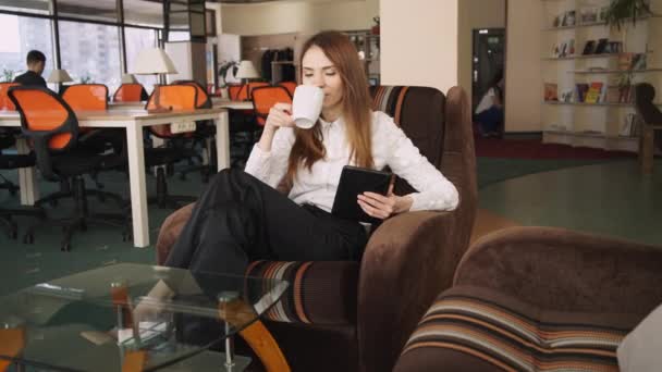 Vrouw besteedt vrije tijd op een co-werken. Ze lezen grappig nieuws op sociaal netwerk. - Video
