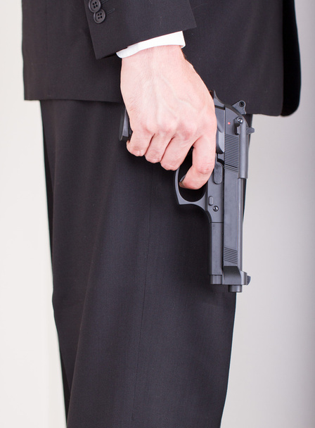 άνθρωπος με όπλο, επαγγελματικό κοστούμι, εστίαση του όπλου - Φωτογραφία, εικόνα