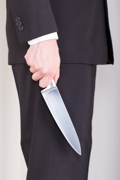 Man with knife, business suit, focus on the knife - Photo, Image