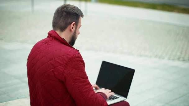 Jeune homme travaillant sur ordinateur portable moderne à l'extérieur
 - Séquence, vidéo