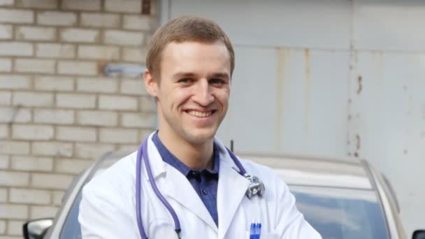 Portrait of young caucasian medical doctor smiling outdoor - Footage, Video