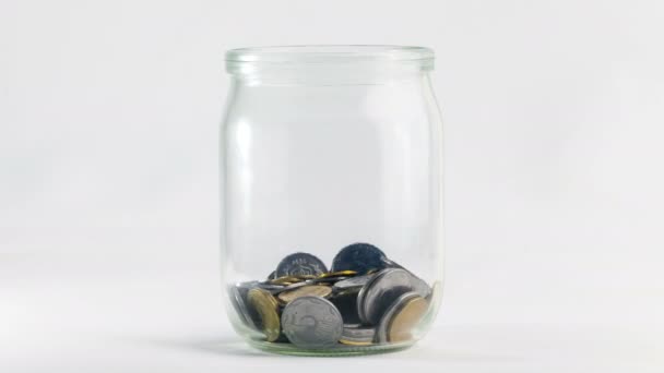 Time Lapse of Falling Coins in the Jar sobre fundo branco. Clipe de vídeo 4K Ultra HD 3840x2160
 - Filmagem, Vídeo
