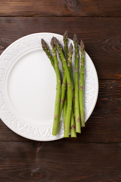 Fresh asparagus shoots on a plate - Fotoğraf, Görsel