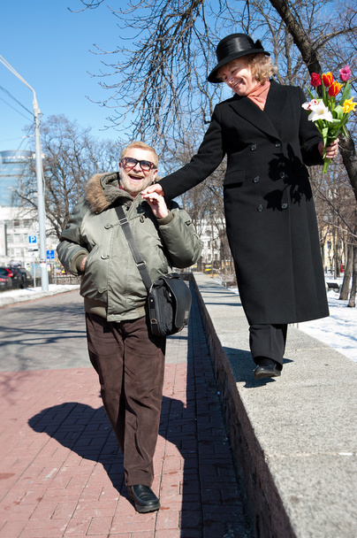 Усміхнений старий чоловік тримає руку своєї жінки
 - Фото, зображення