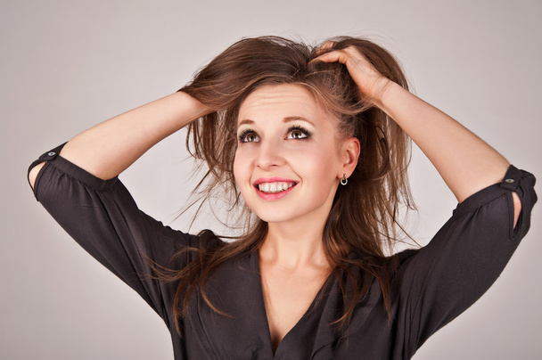 Onnellinen nuori nainen kädestä hiuksissaan
 - Valokuva, kuva