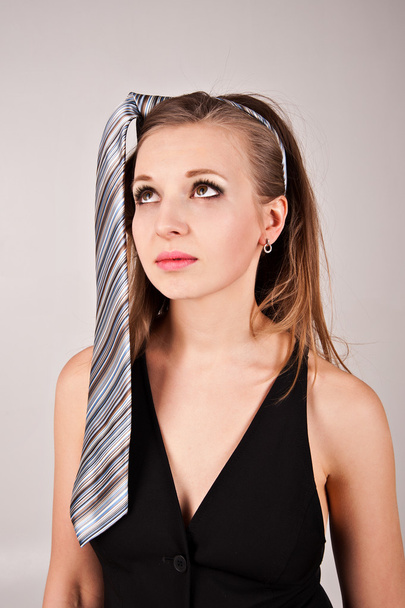 Jolie jeune femme avec cravate rayée sur la tête
  - Photo, image