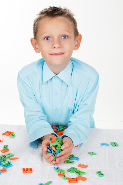Lindo chico de la escuela está jugando con letras de plástico
 - Foto, Imagen