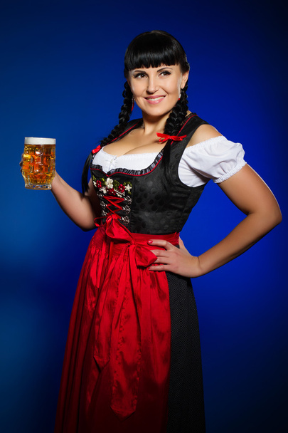 Gyönyörű barna nő a bajor öltözött pohár sör - Fotó, kép