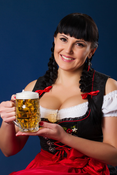 Mooie brunette vrouw in Beierse gekleed met glas bier - Foto, afbeelding