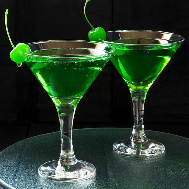 Green cocktail with maraschino cherry in a martini glasses - Photo, Image