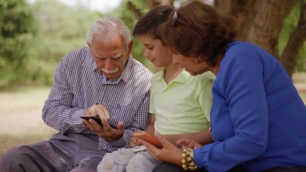 Boy Helping Grandpa Surfing Internet On Mobile Phone - Footage, Video