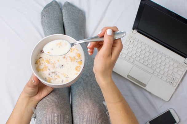 Woman eating cereals in bed - Photo, Image
