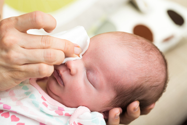 Mãe limpeza olhos de um bebê recém-nascido
 - Foto, Imagem