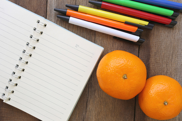 Notebook a mandarinky na staré dřevo pro návrh backgro - Fotografie, Obrázek