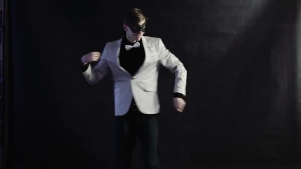 Мужчина танцует в белом костюме на черном фоне
 - Кадры, видео