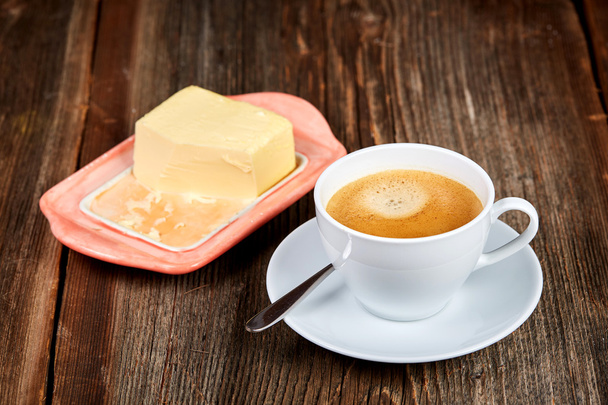 Café y mantequilla en un plato sobre una mesa de madera
 - Foto, Imagen