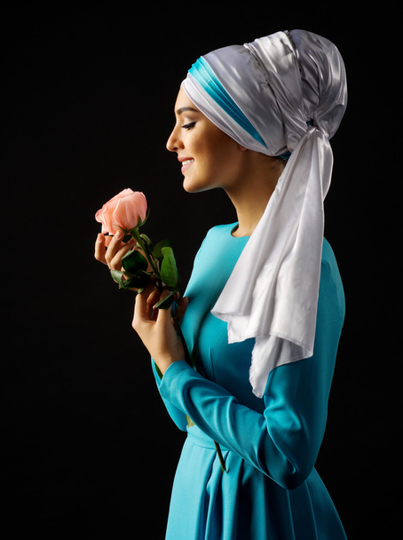 Muslim woman in blue dress with rose - Fotoğraf, Görsel