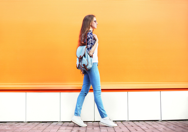 Fashion woman walking in city over colorful orange background - Φωτογραφία, εικόνα