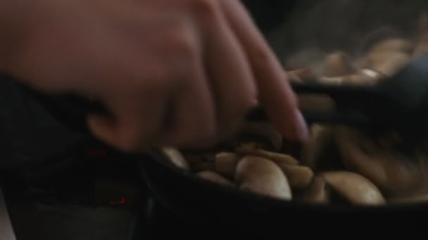 Ανακατεύοντας τα μανιτάρια και τα κρεμμύδια σε ένα τηγάνι closeup - Πλάνα, βίντεο