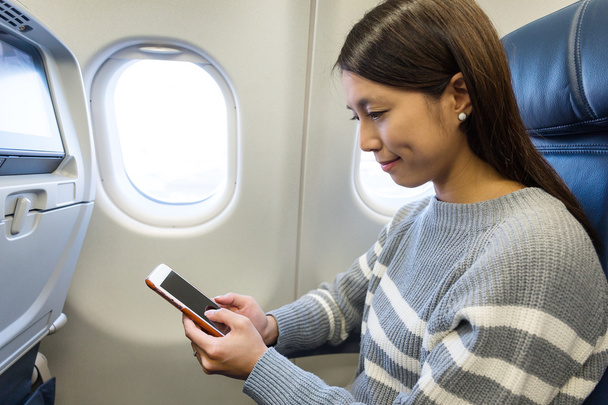 Frau benutzte Handy im Flugzeug - Foto, Bild