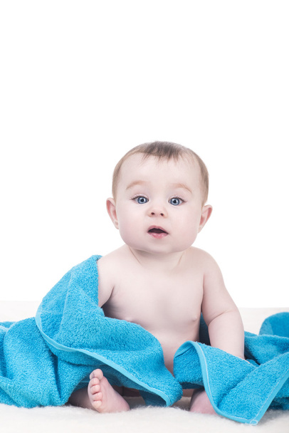 χαριτωμένο baby sitting με κουβέρτα με μπλε πετσέτα/κουβέρτα - Φωτογραφία, εικόνα