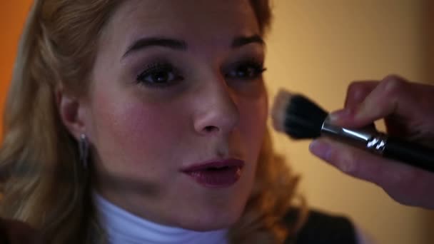 Happy client sitting in beauty salon. Skilled artist applying makeup on skin - Záběry, video