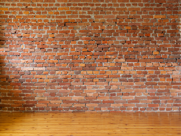 Интерьер с красными кирпичными стенами и деревянными полами из досок
 - Фото, изображение
