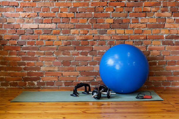 The mat, fitball, rope, dumbbells and stand push-ups lie on the  - Photo, Image