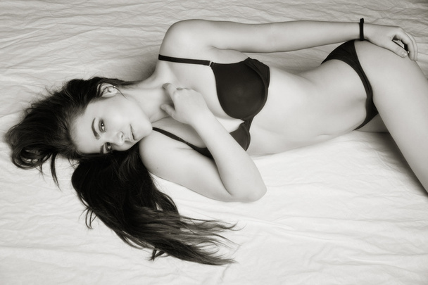 Αισθησιασμό σέξι γυναίκα με ένα τέλειο σώμα, ξαπλωμένη στο κρεβάτι - Φωτογραφία, εικόνα