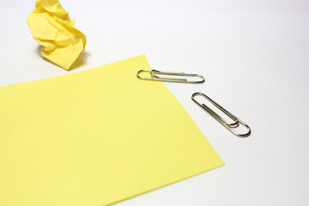 Nota amarilla con clip sobre fondo blanco
 - Foto, Imagen