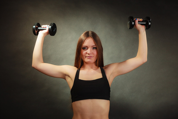 Fit woman exercising with dumbbells. - Фото, изображение