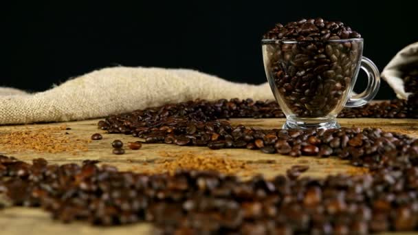 Path made with coffee beans on wooden table, cup and bag with coffee beans on background, dolly - Footage, Video