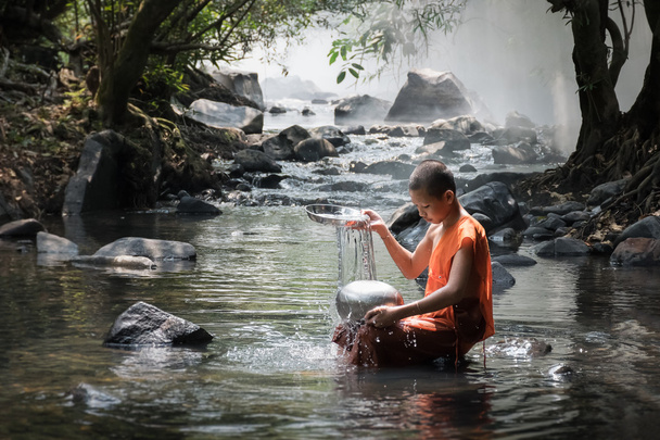 Neófito está lavando su contenedor en el río. Sangkhom, Nong khai, Tailandia
. - Foto, imagen