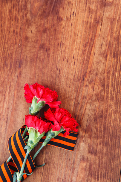 Символи перемоги у трьох Червона квітка Великої Вітчизняної війни і Джордж стрічки на дерев'яні таблиці - Фото, зображення