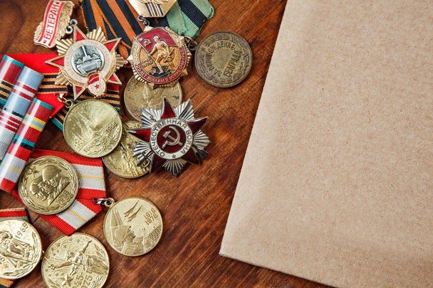 Las medallas de la URSS y los méritos de los años diferentes y el papel sobre una mesa. imagen de enfoque selectivo
 - Foto, Imagen