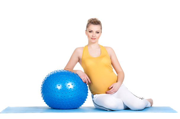 A pregnant woman does gymnastics with ball - Foto, afbeelding