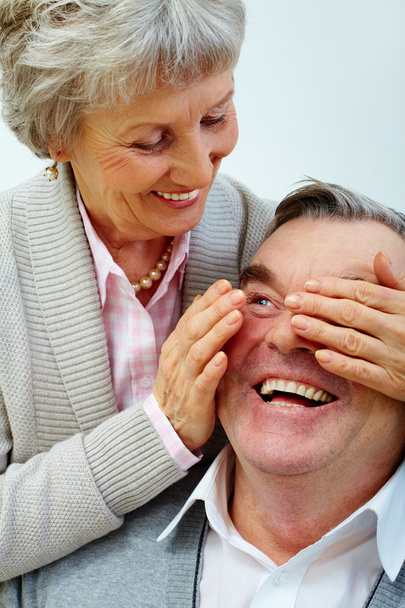 Vrij senior vrouw sluit man's ogen door handen - Foto, afbeelding