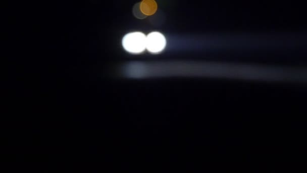 Κινούμενο αυτοκίνητο με φώτα τη νύχτα. Το αυτοκίνητο πηγαίνει στο δρόμο άδειο νύχτα. Στο απόλυτο σκοτάδι να δει μόνο το φωτεινό φως του προβολείς αυτοκινήτων. - Πλάνα, βίντεο