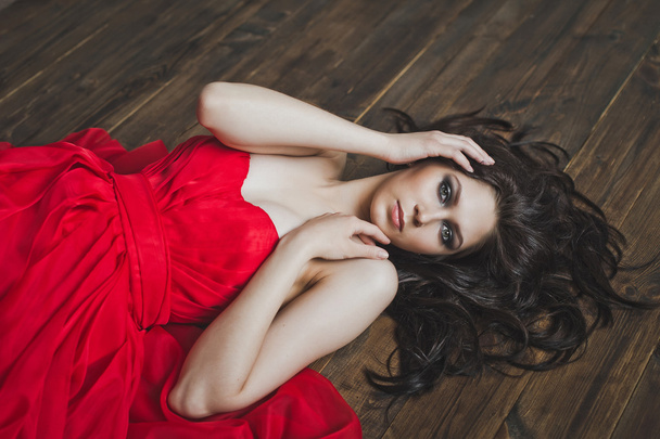 Girl in dress lying on wooden floor 5996. - Fotó, kép