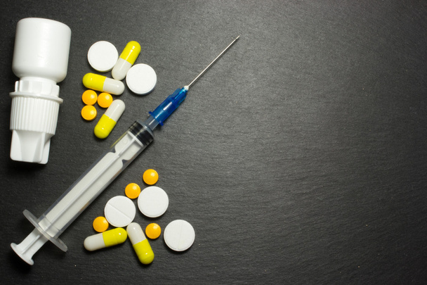Medical syringe and pills on dark background - Photo, Image