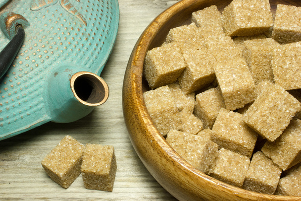 Cubes brown cane sugar in a plate on wooden background - Photo, Image